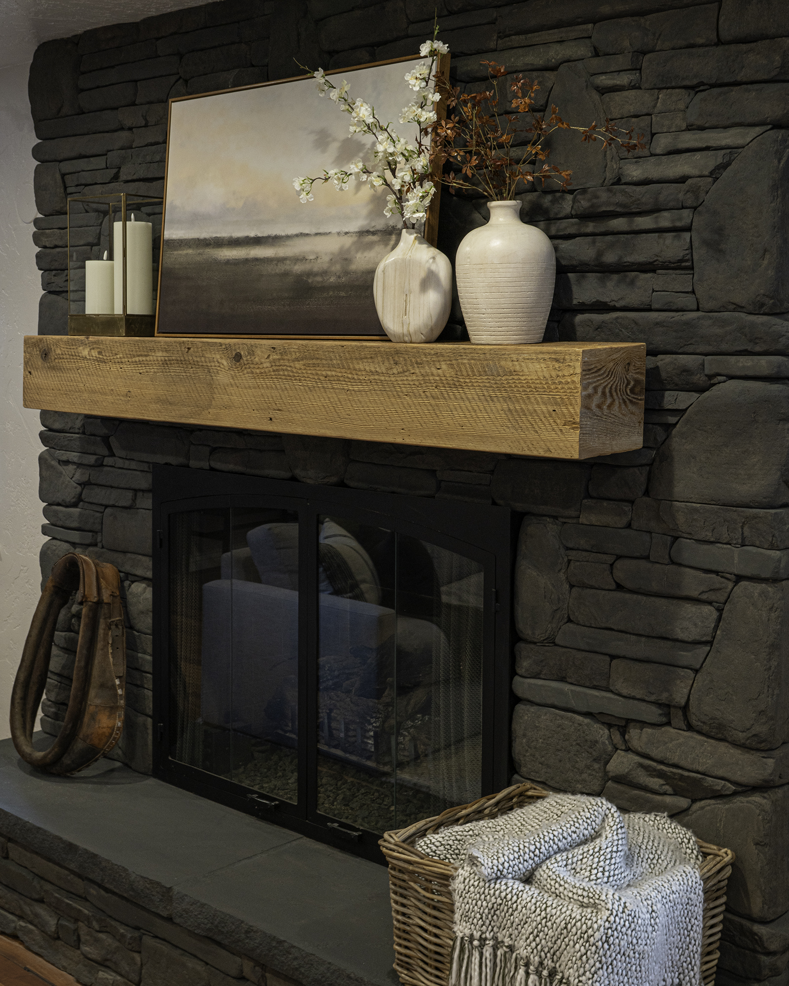 Dark grey wash painted stone fireplace styled for spring