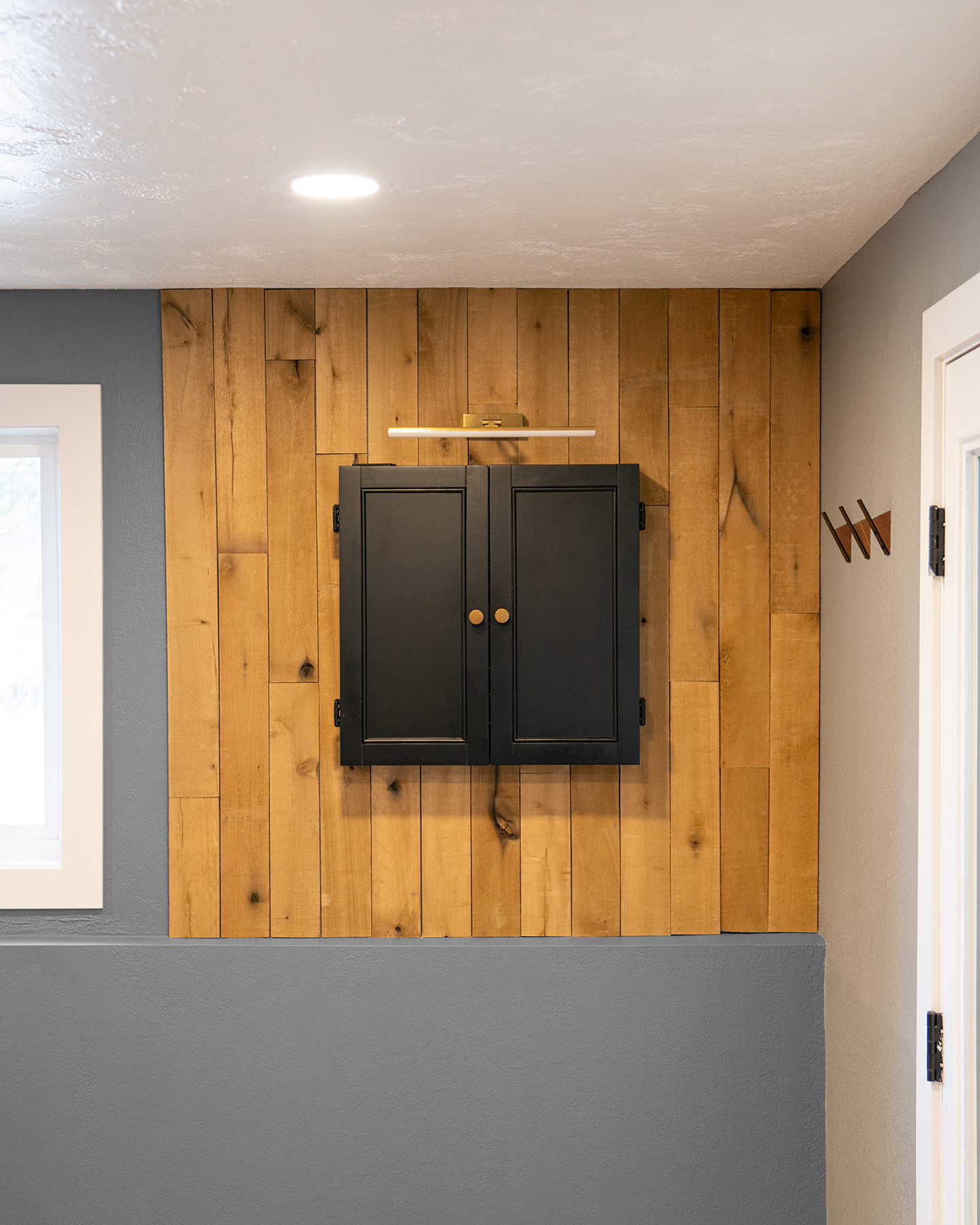 dartboard cabinet closed on wood panel wall