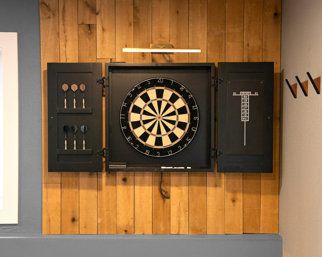 dartboard cabinet on wood panel wall