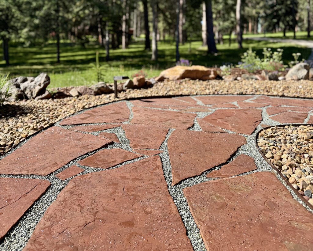beautiful red flagstone pathway with grey crushed granite pea gravel glued with rock and gravel glue and sealed in Colorado mountains